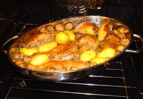 Pieczona kaczka z ziemniakami i pieczarkami.