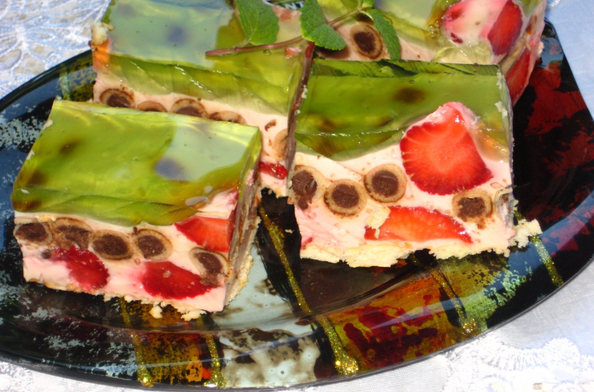 Sernik z czekoladowymi rurkami i truskawkami.