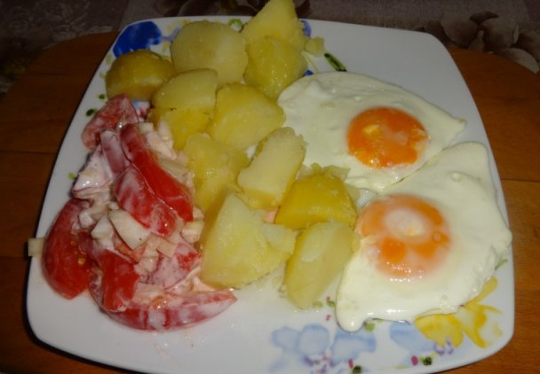 Jajka sadzone, młode ziemniaki i mizeria z pomidora.