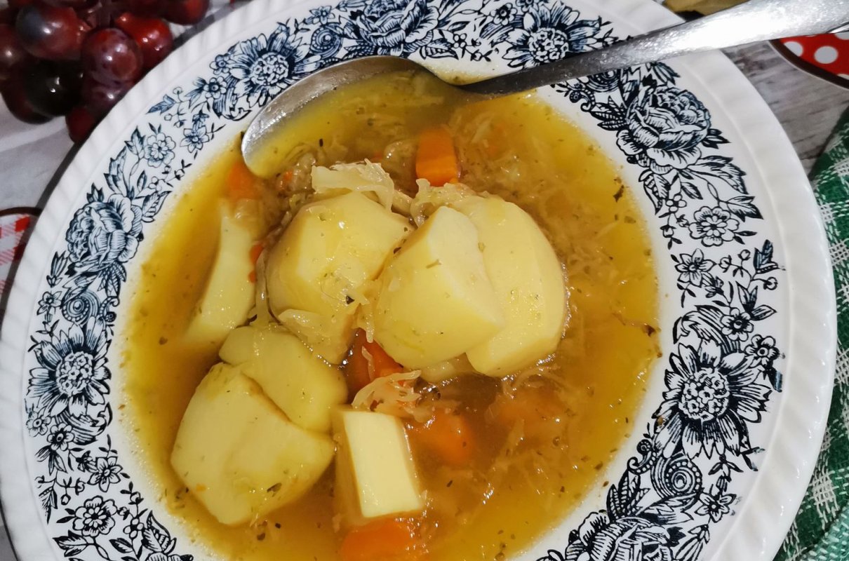 Kapuśniak na wywarze z gotowanego boczku z ćwiartkami ziemniaków.