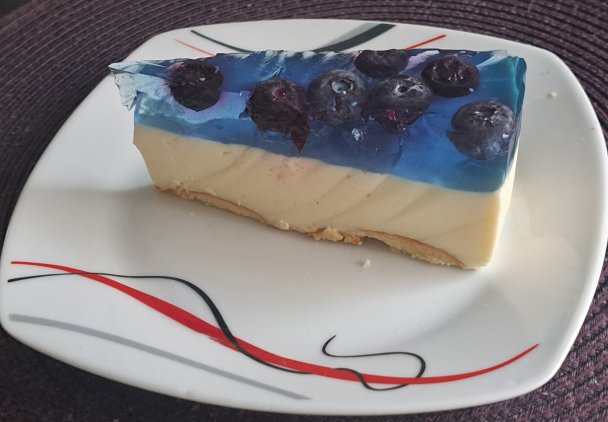 Sernik bez pieczenia z borówką amerykańską i niebieską galaretką.