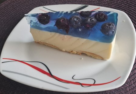 Sernik bez pieczenia z borówką amerykańską i niebieską galaretką.