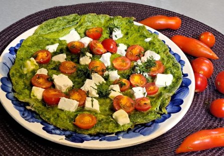 Zielony omlet z pomidorkami koktajlowymi i serem feta.